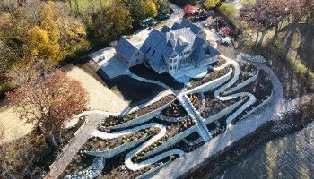 Aerial view of large home with walkways and landscape.