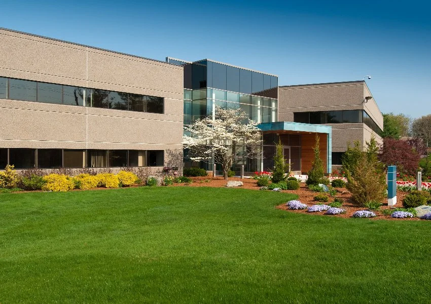 Modern office building with landscaped greenery and flowering trees in Huron, OH.