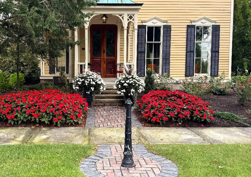 Home with a sidewalk and plants with red flowers in Huron, OH.