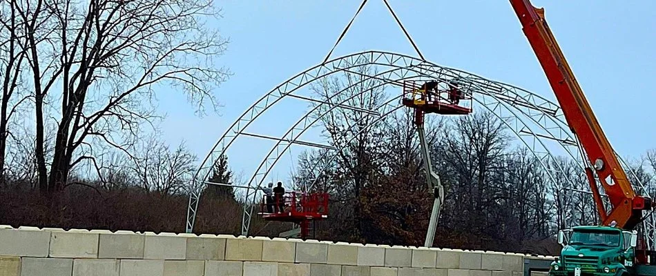 Crane lifting a large construction piece at a commercial site in Huron, OH.