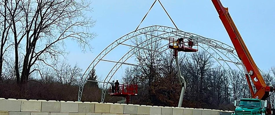 Crane lifting a large construction piece at a building site in Huron, OH.