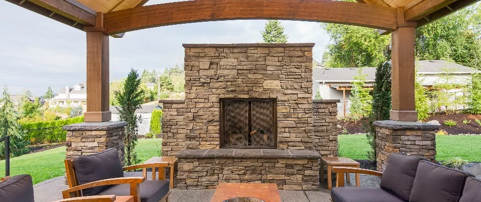 Outdoor fireplace on a pavilion in Huron, OH, with furniture.