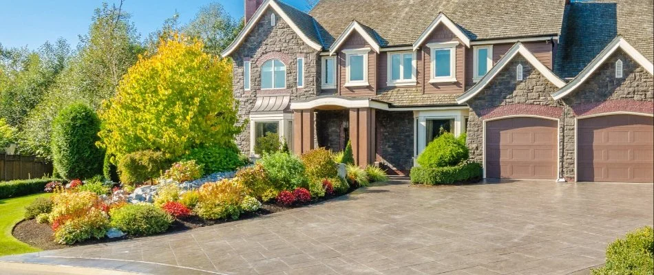 Elegant home with a spacious stamped concrete driveway, lush landscaping, and a well-maintained front yard in Huron, OH.