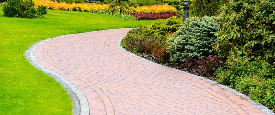 Walkway in Huron, OH, along shrubs and a lawn.